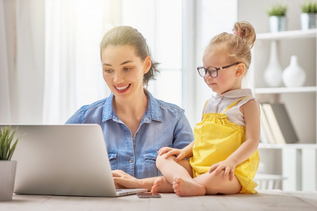 Mother and daughter working from home at a computer together