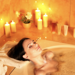 Woman taking a bubble bath with candles