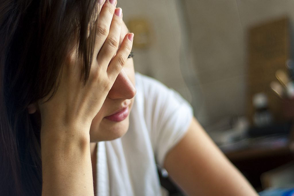 Depressed woman holding her head in frustration or tiredness